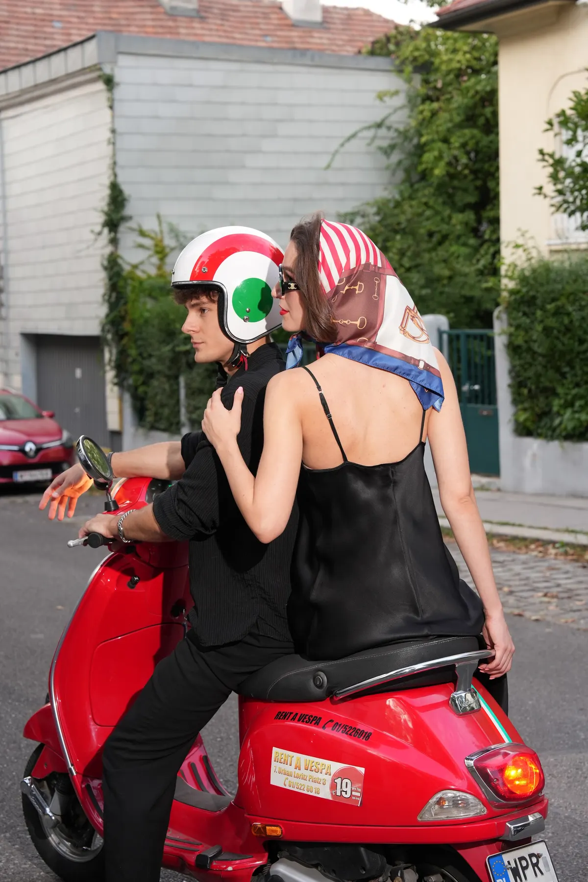 Couple riding off on a Vespa