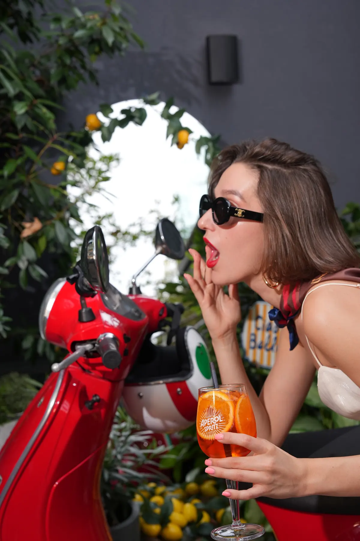 Guest with a spritz by the red Vespa